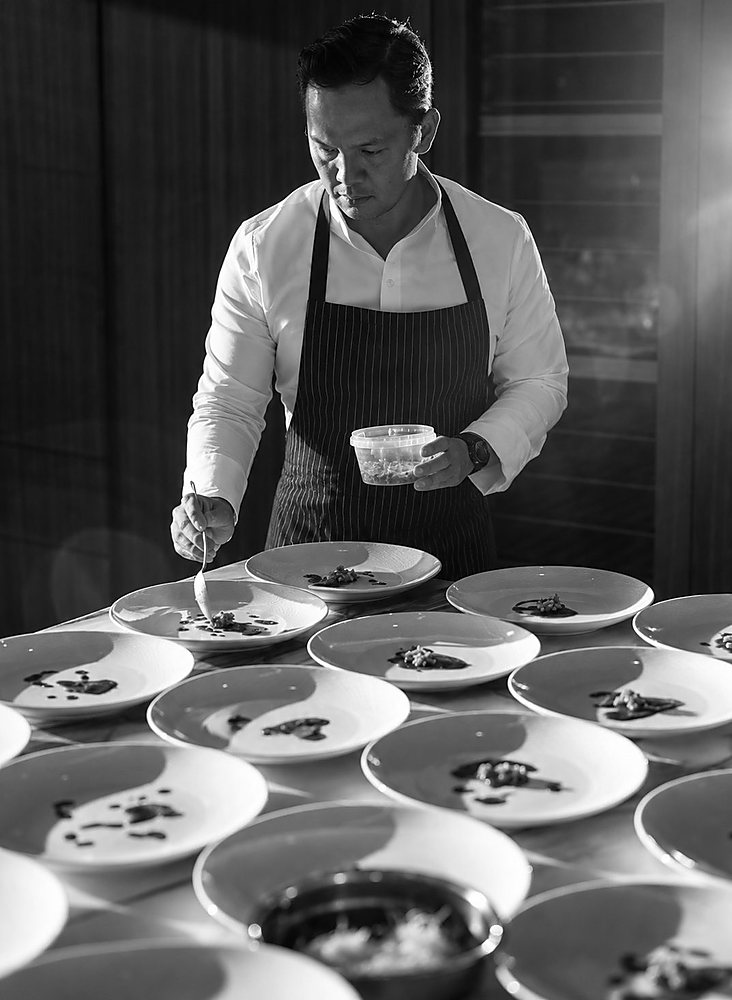 Chef André Villahermosa finishing a plated course with a spoon