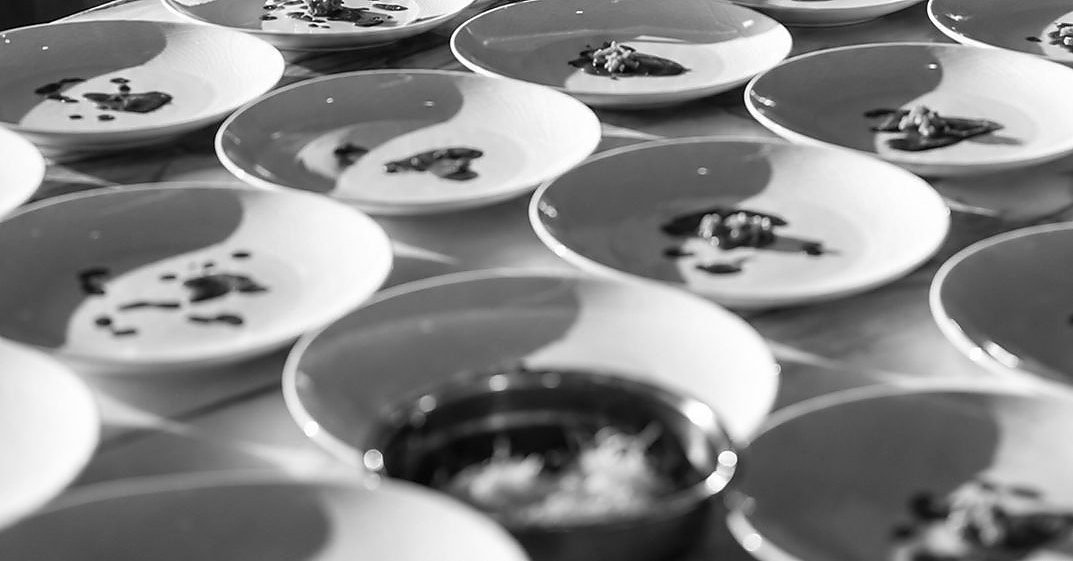 Finished plates on the pass, each dressed identically before service